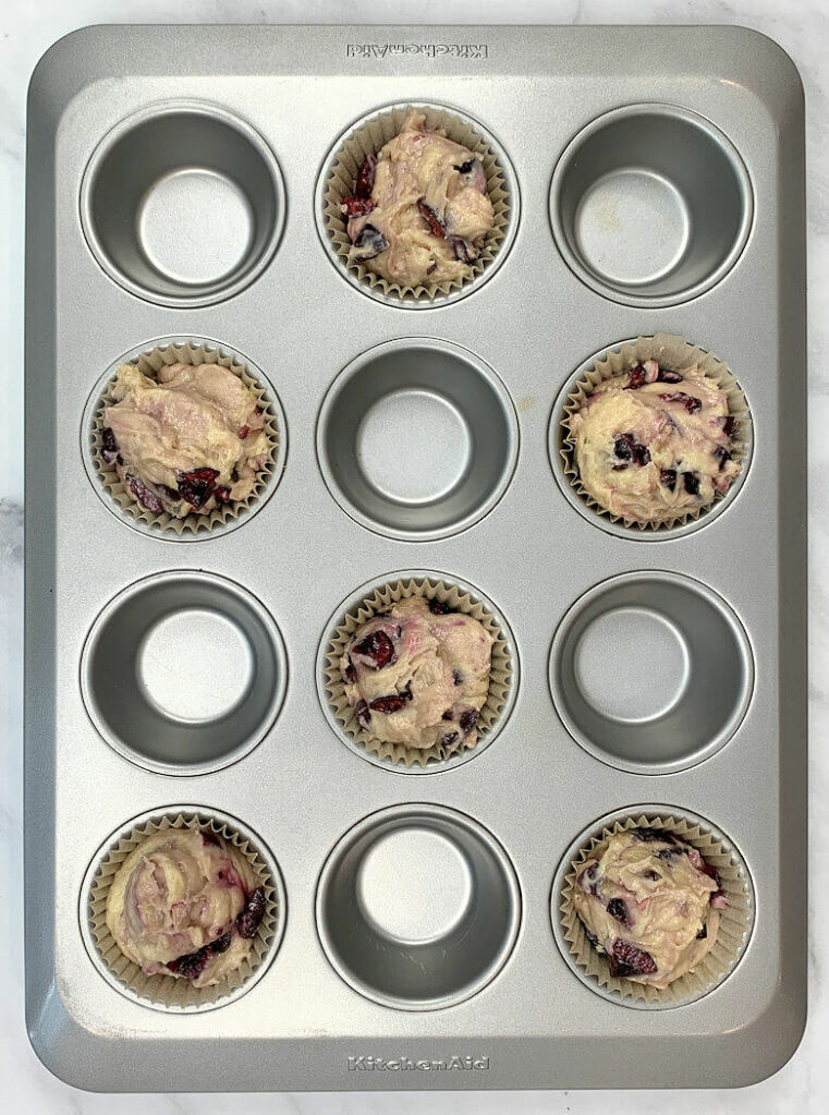 muffin pan with 6 muffins holes filled with batter