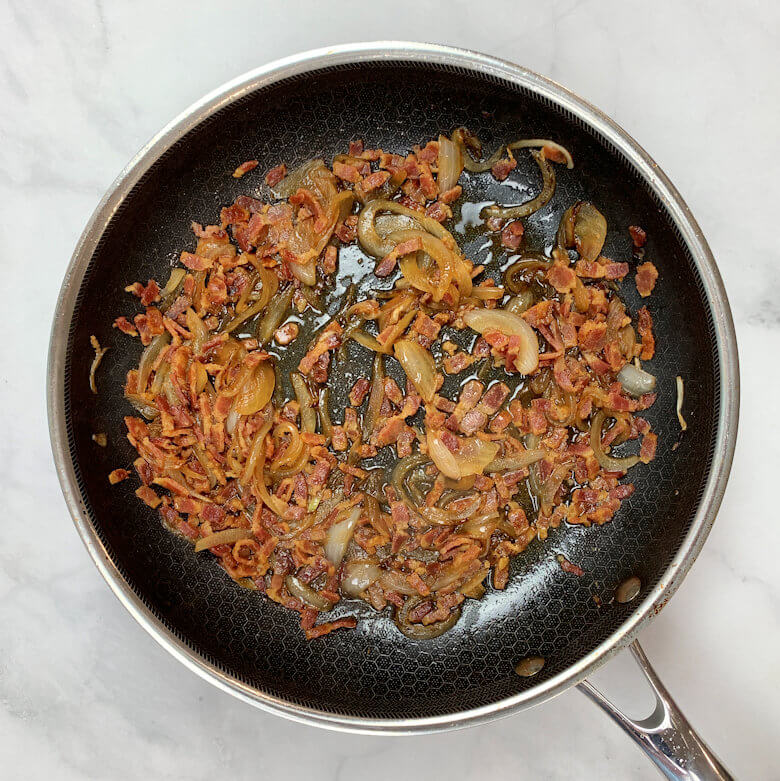 Skillet with sauteed bacon and caramelized onion