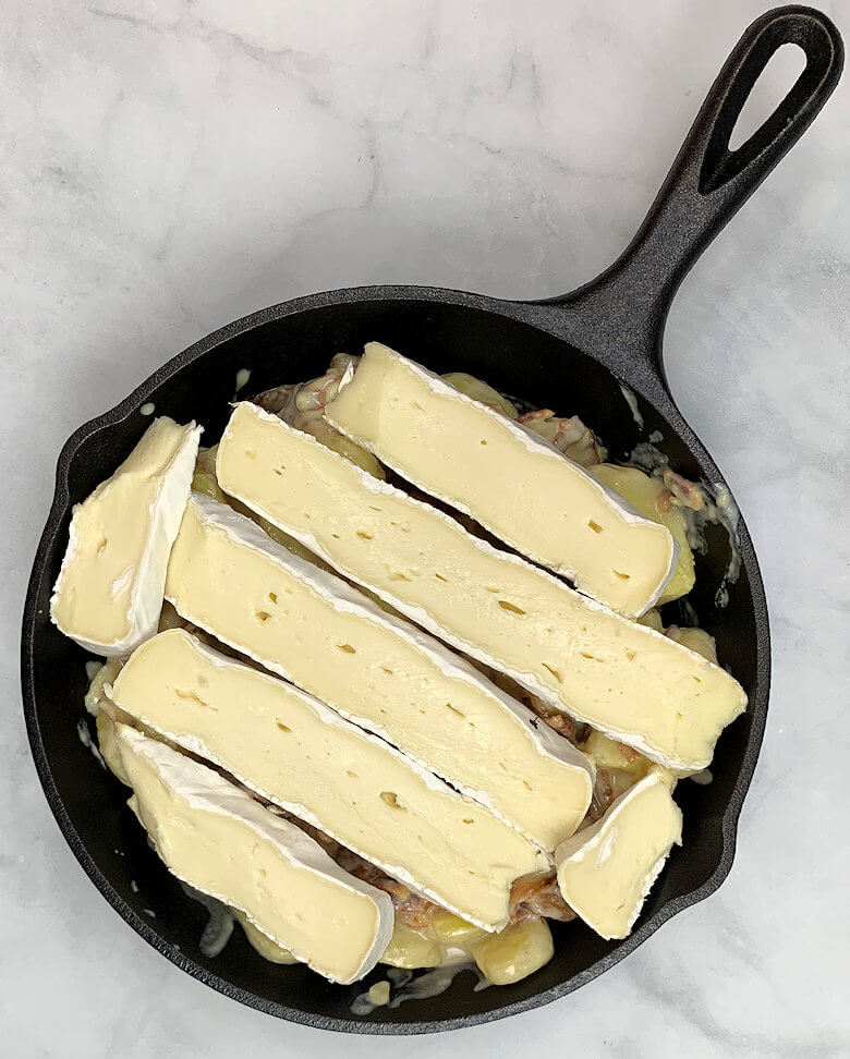 Tartiflette with slices of Brie cheese on top, ready to go into the oven