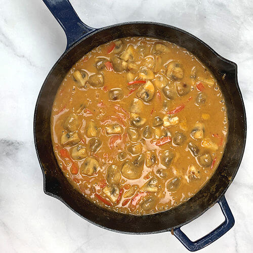 Added chicken broth, creme fraiche, mustard, red bell pepper and paprika powder to skillet.