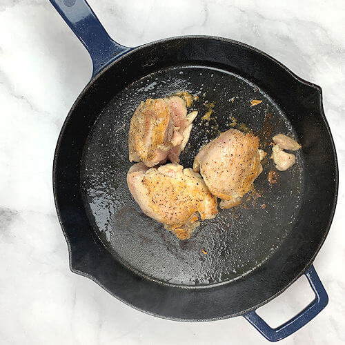 Chicken thighs sauteed in skillet.